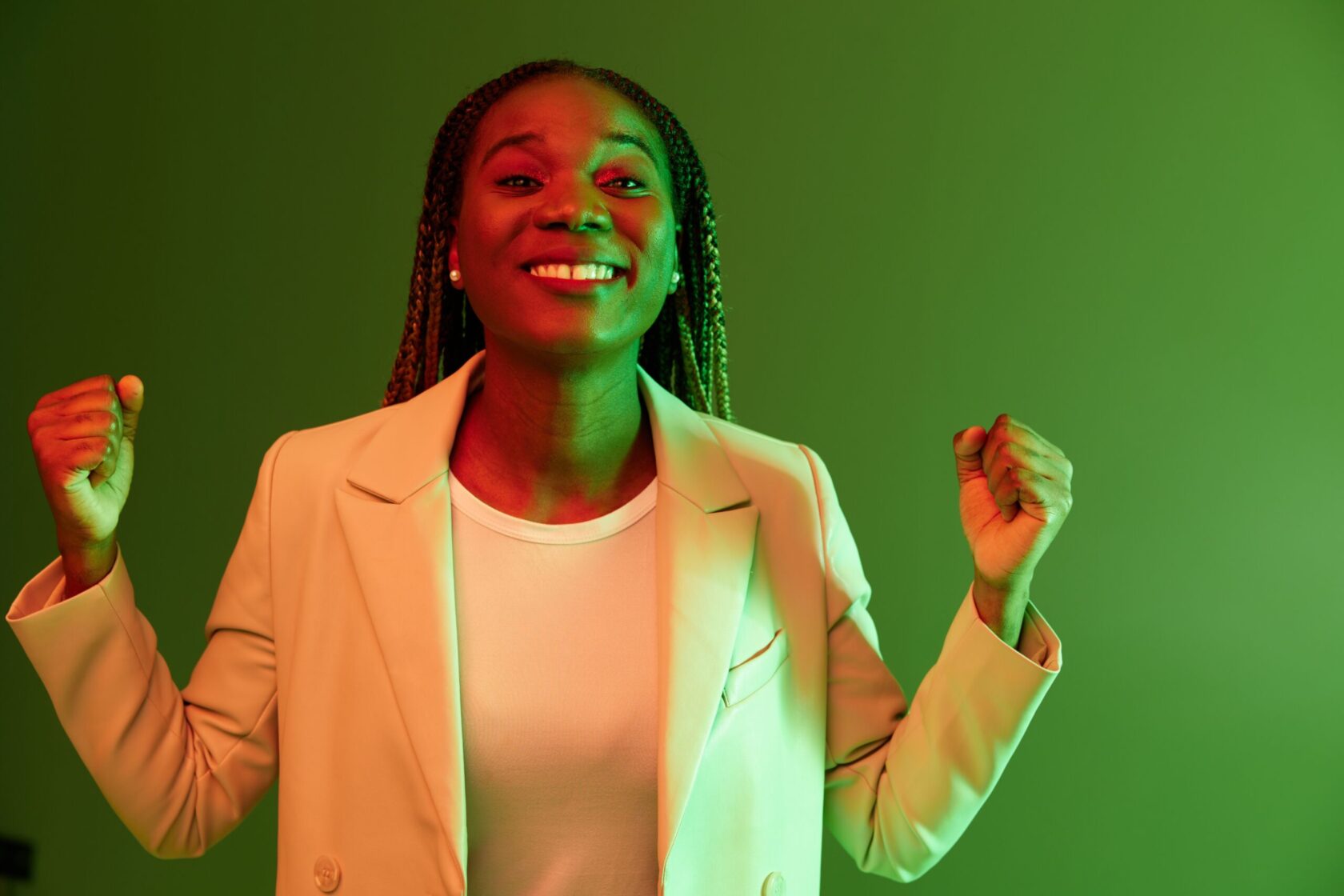 African american woman portrait business smile on green background in neon light, color mixed light, bright colors. Beauty African American woman with pigtails emotions. High quality photo